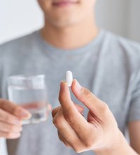 man taking pill with water