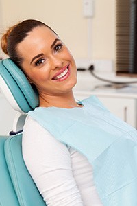 Woman sitting in dental chair and smiling