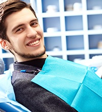 Bearded man sitting in dental chair and smiling